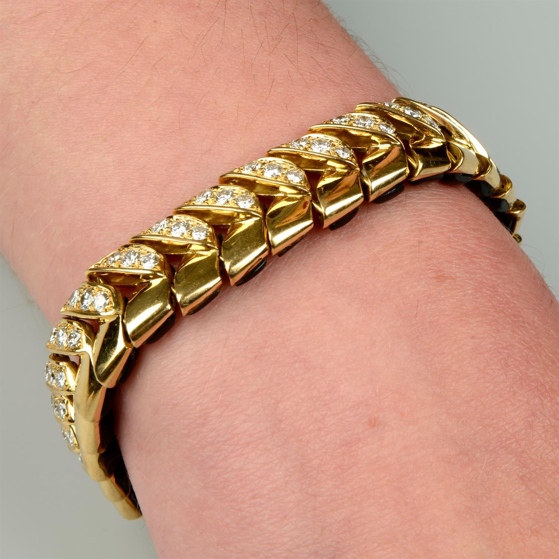 A mid 20th century 18ct gold onyx and brilliant-cut diamond reversible panel bracelet,
