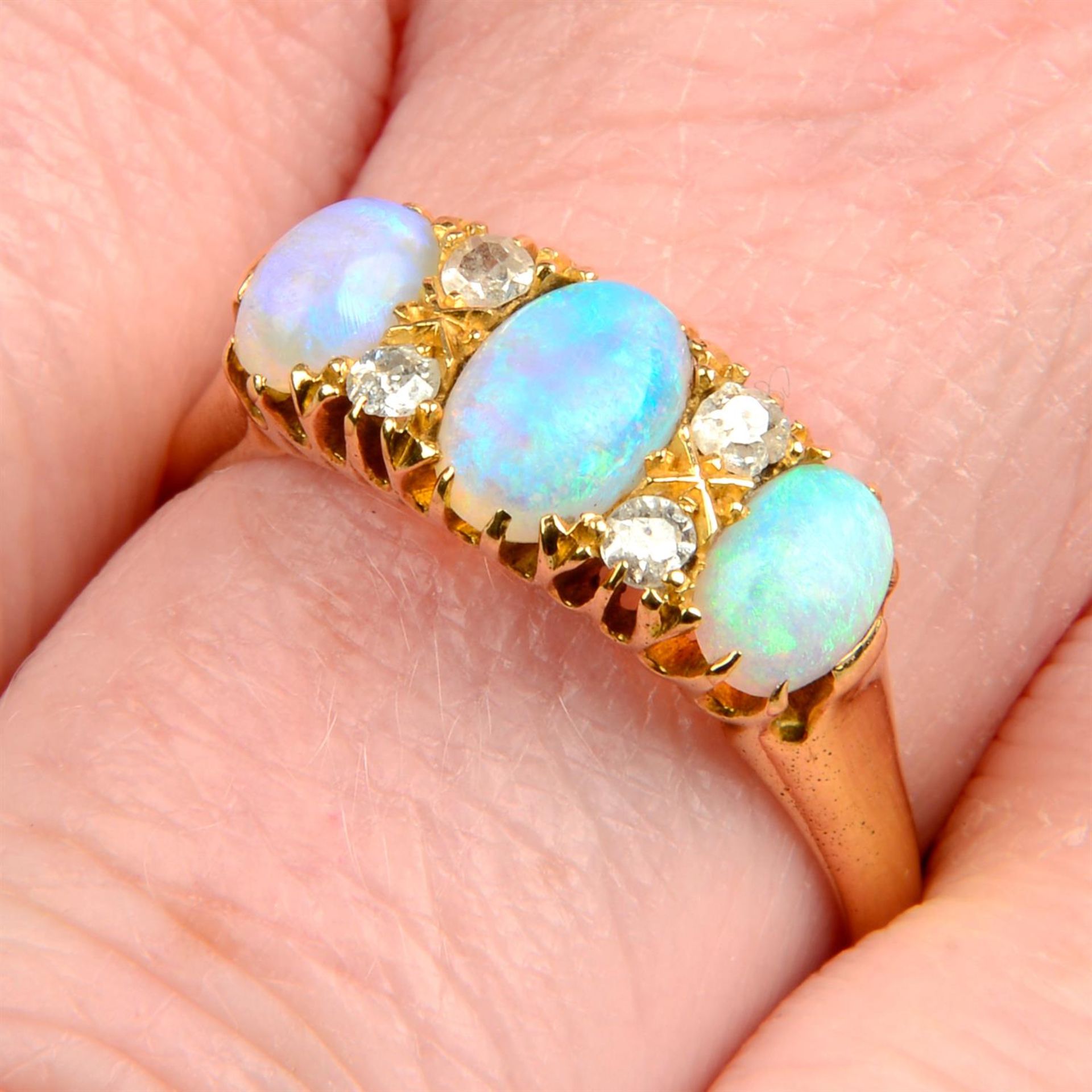 A late Victorian 18ct gold opal three-stone ring, with old-cut diamond spacers.