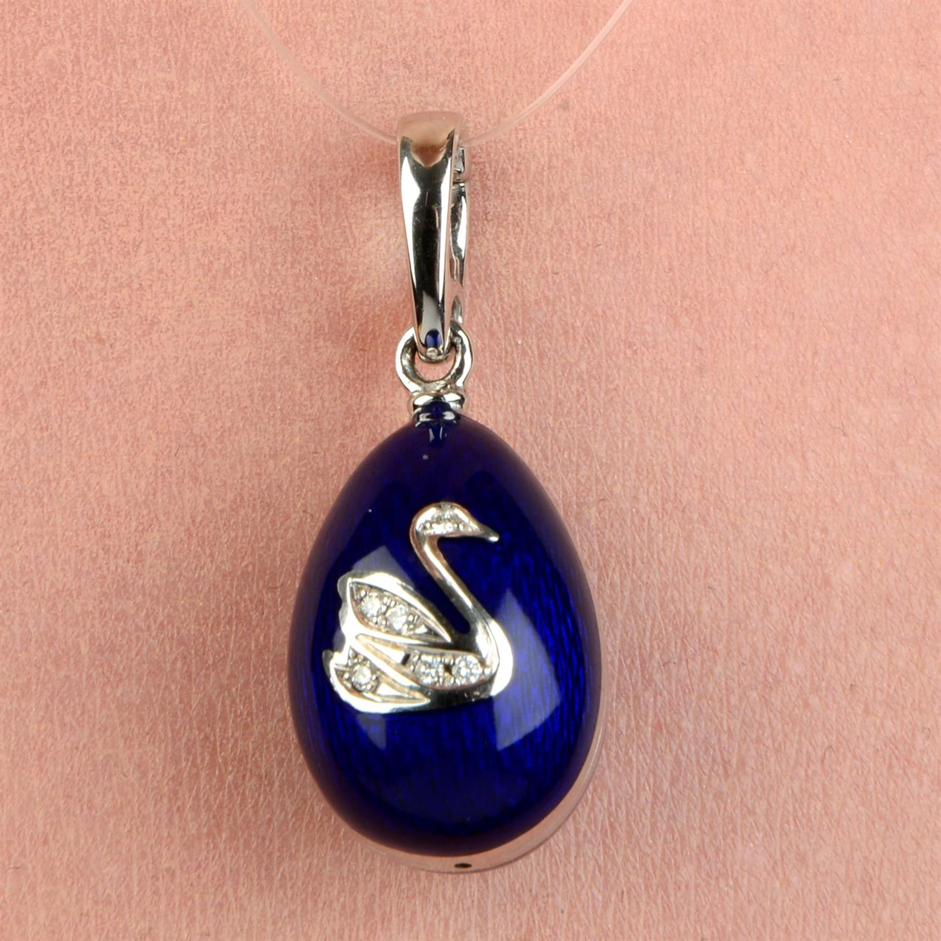 A limited edition 18ct gold blue enamel egg pendant, with diamond swan highlight, by Fabergé.