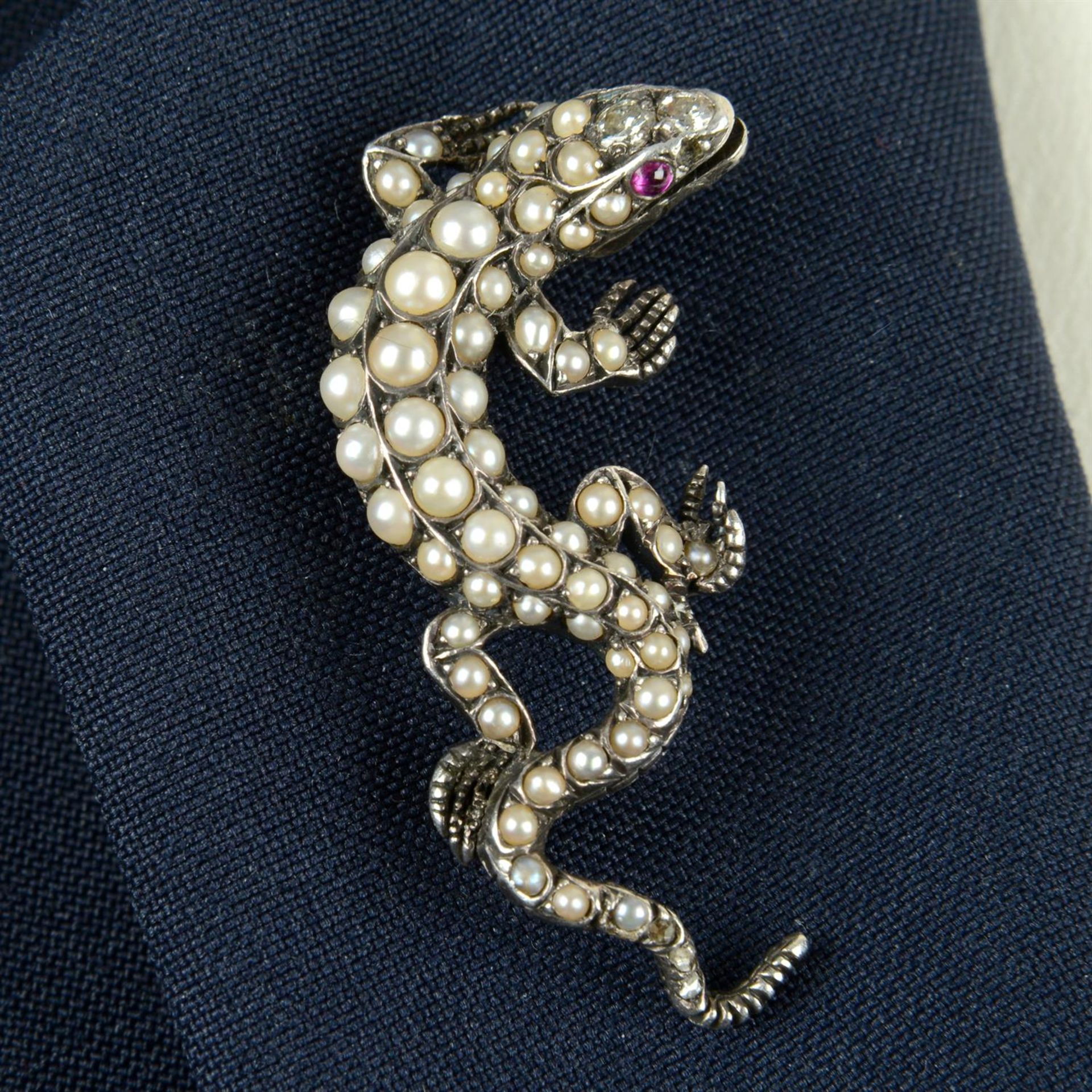 A late Victorian silver split pearl lizard brooch, with circular-cut diamond crest and ruby