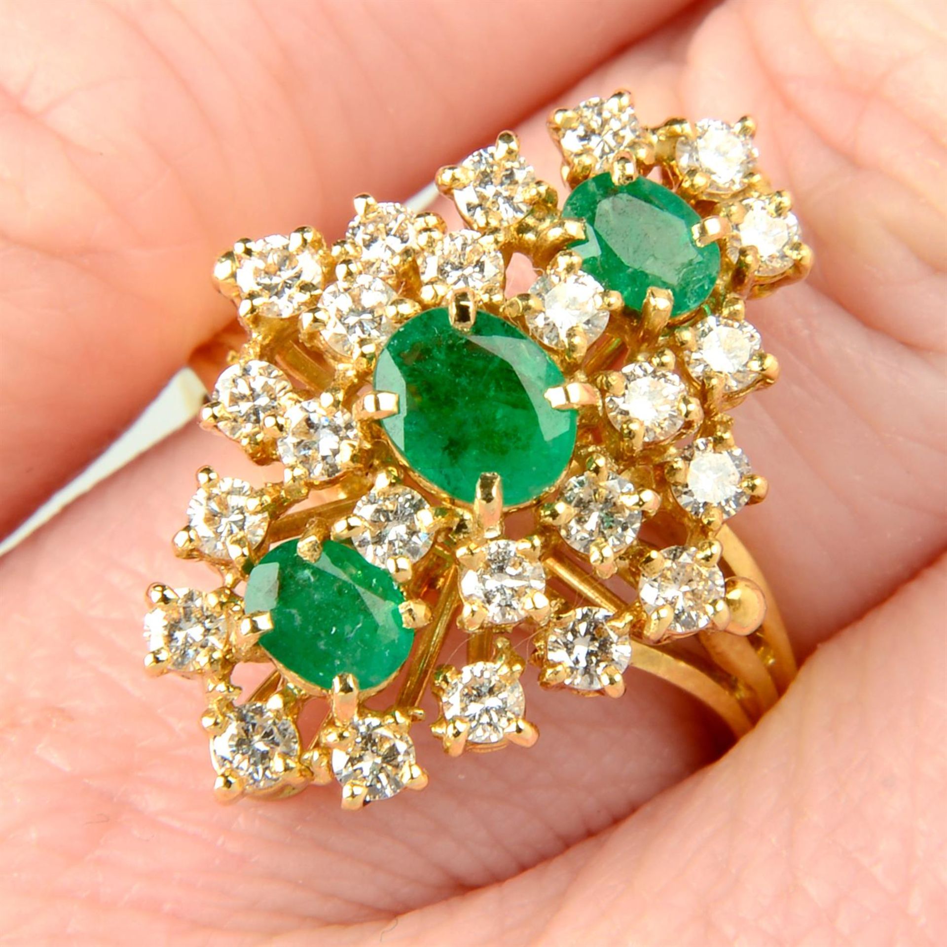 An 18ct gold emerald and brilliant-cut diamond dress ring.