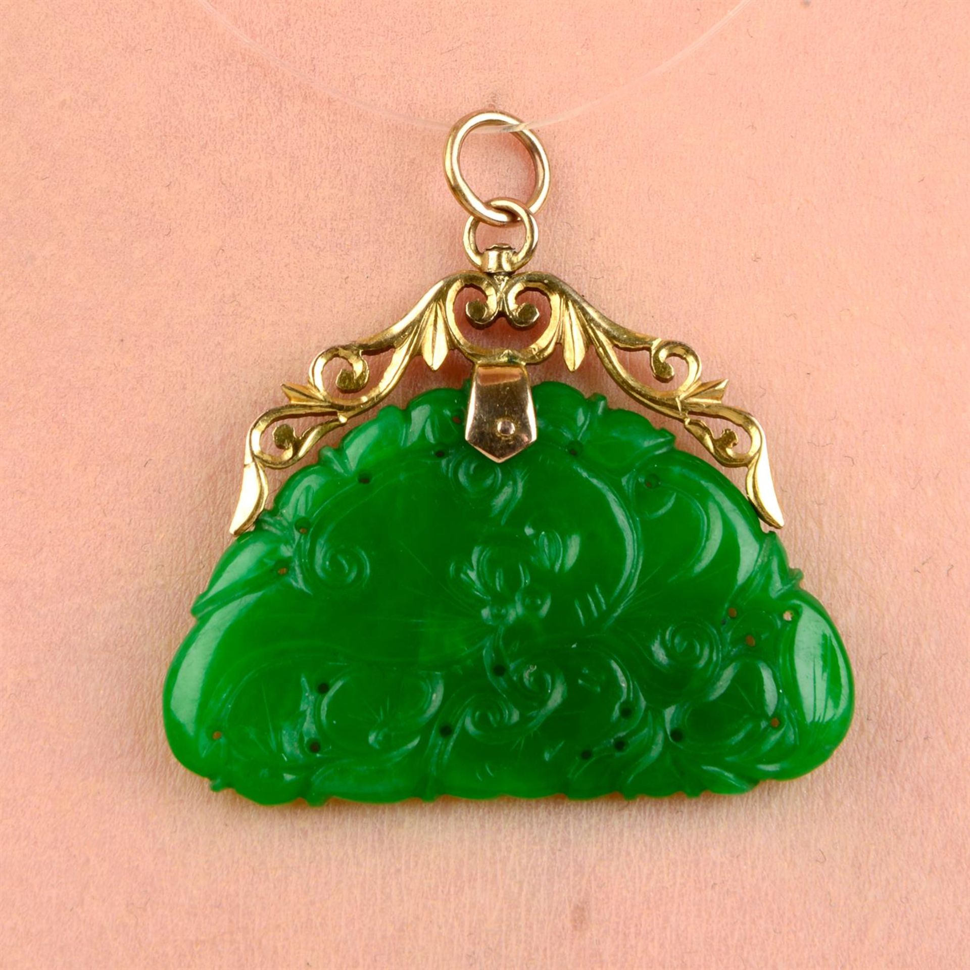 A carved and pierced A-type jadeite jade pendant, with scrolling foliate mount.