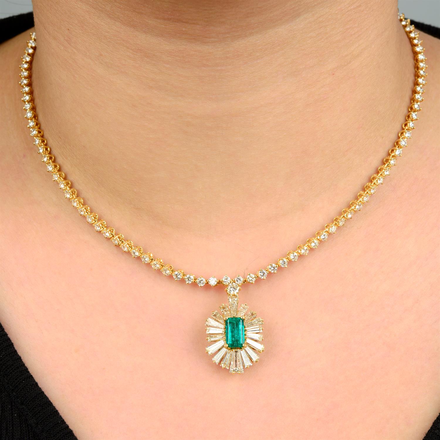 An emerald and tapered baguette-cut diamond pendant, on brilliant-cut diamond chain.