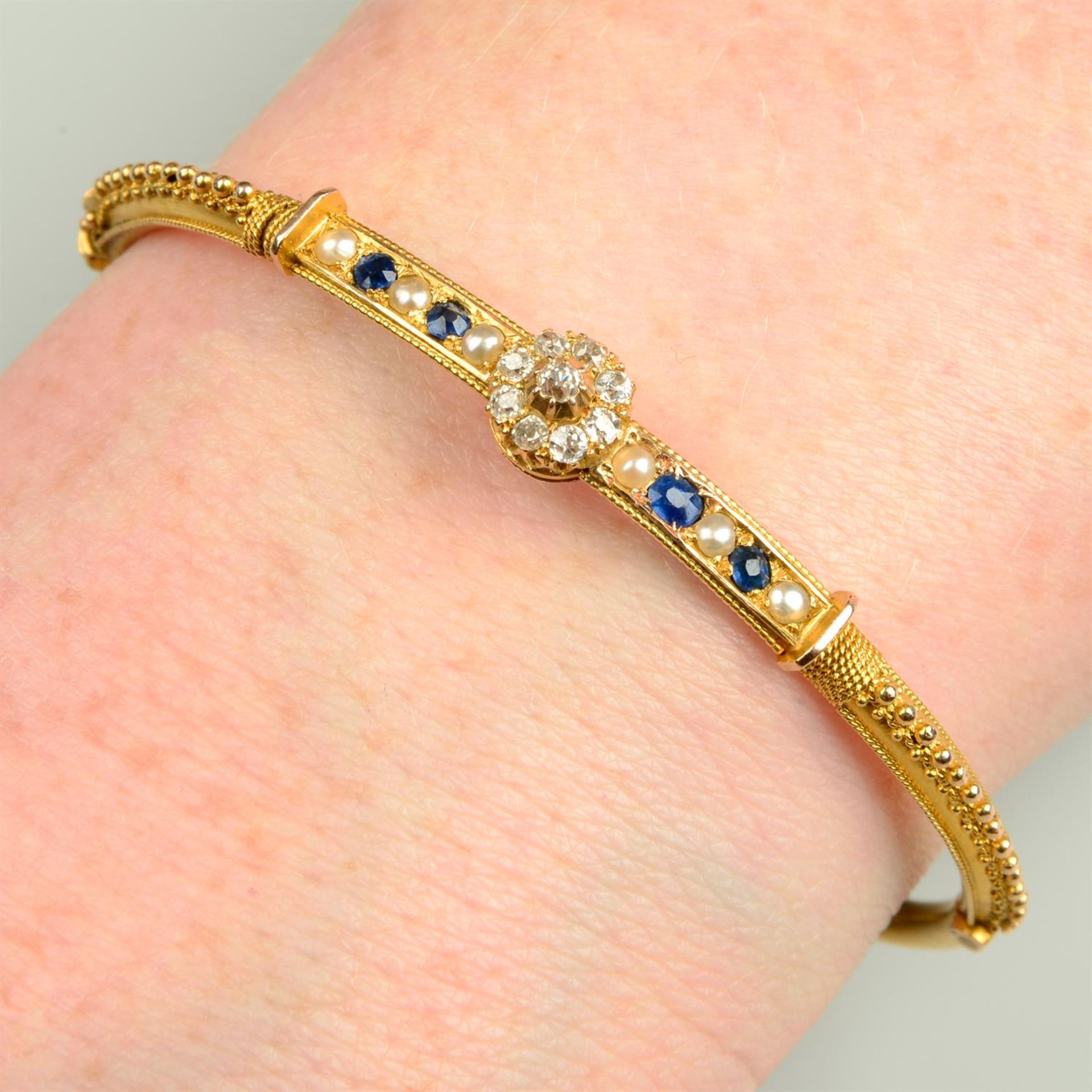 A mid Victorian gold old-cut diamond, sapphire and split pearl cannetille hinged bangle.