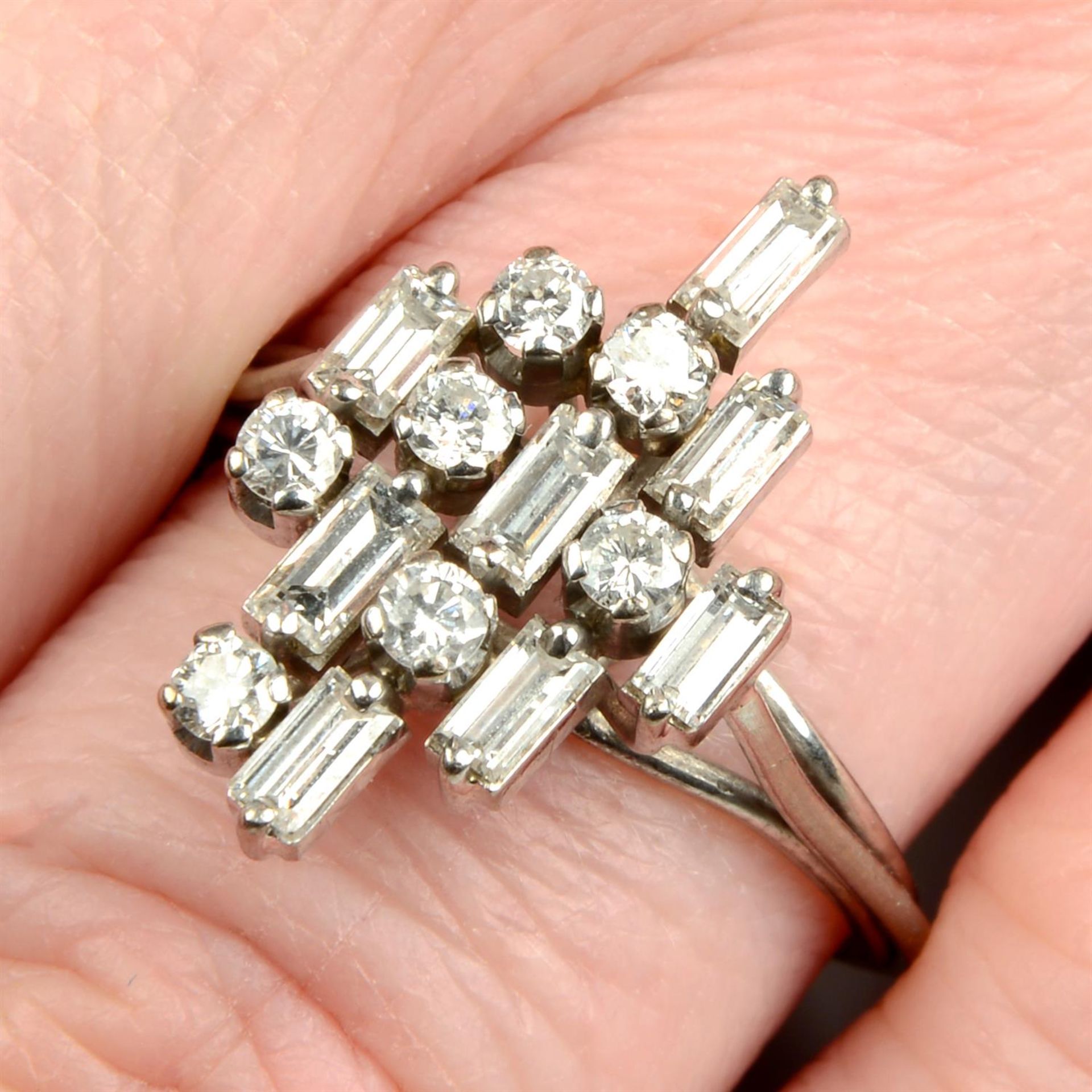 A mid 20th century platinum and gold brilliant and baguette-cut diamond dress ring.