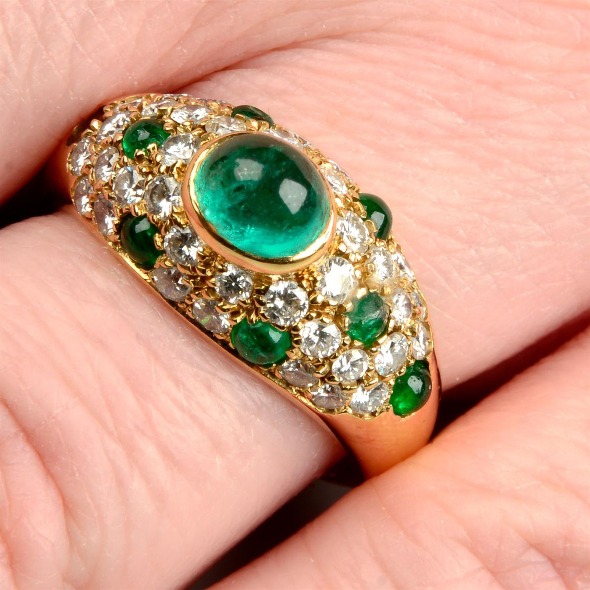 A emerald and brilliant-cut diamond pavé-set band ring.