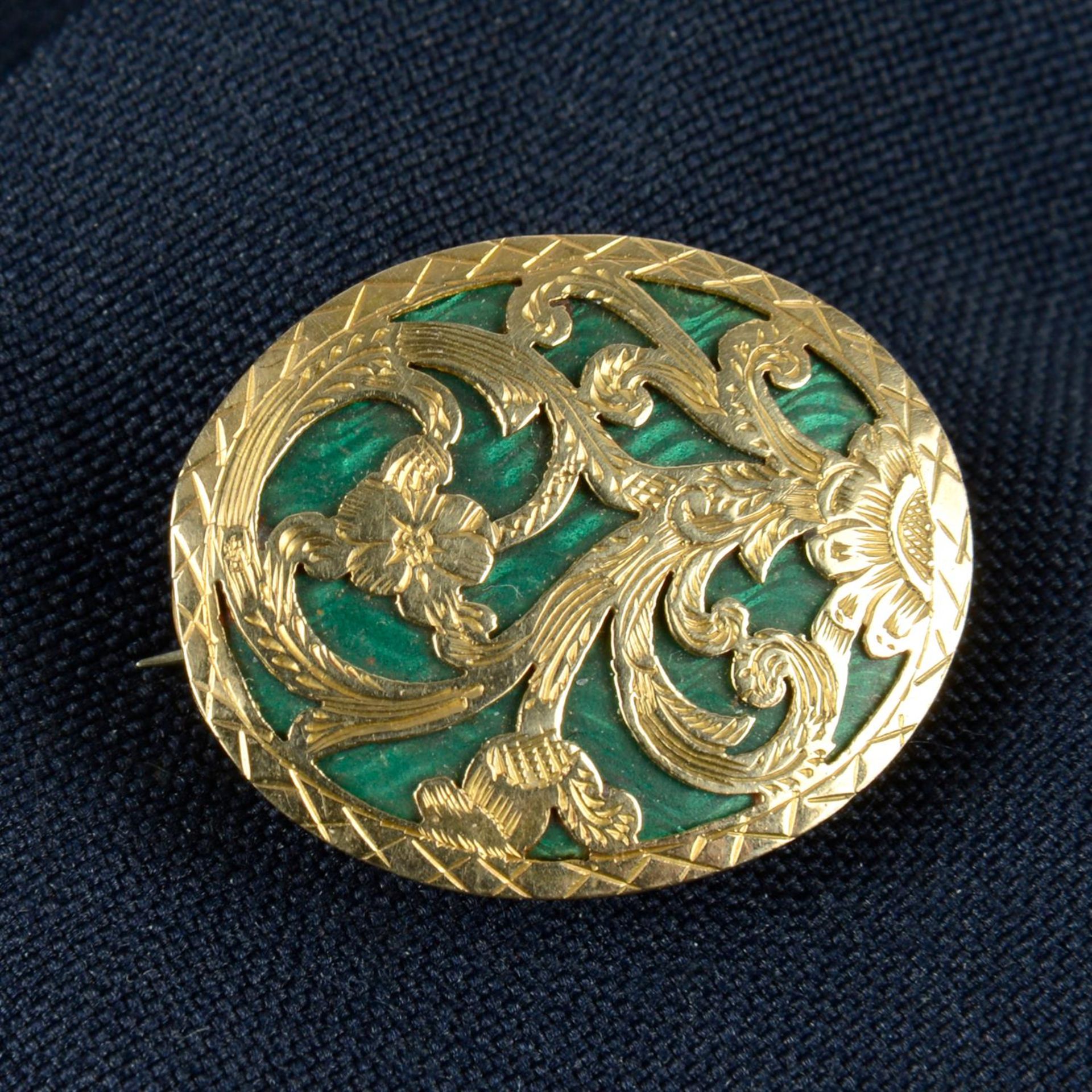 A 19th century green enamel and pierced and engraved floral lattice brooch, with glazed locket