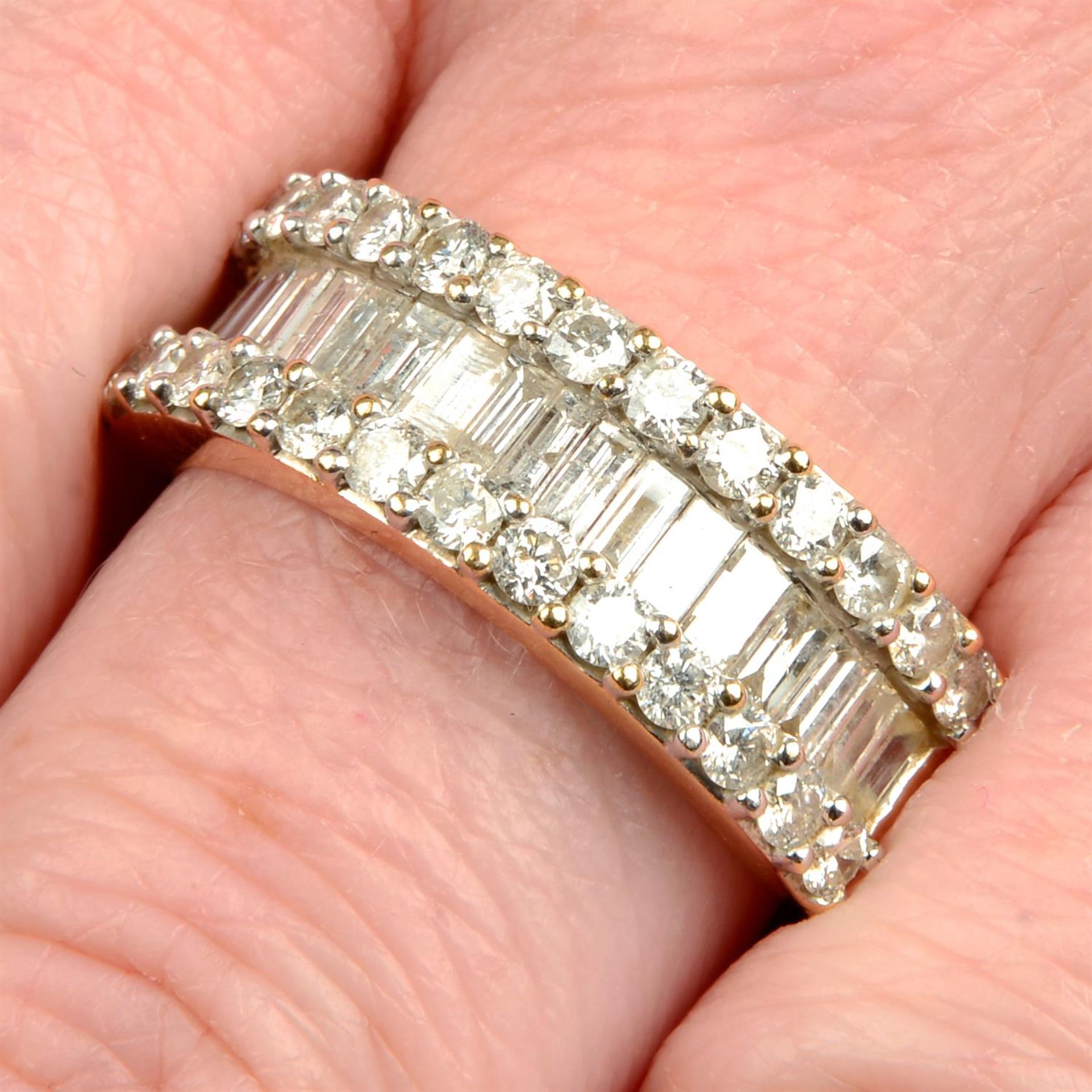 An 18ct gold baguette and brilliant-cut diamond three-row half eternity ring.