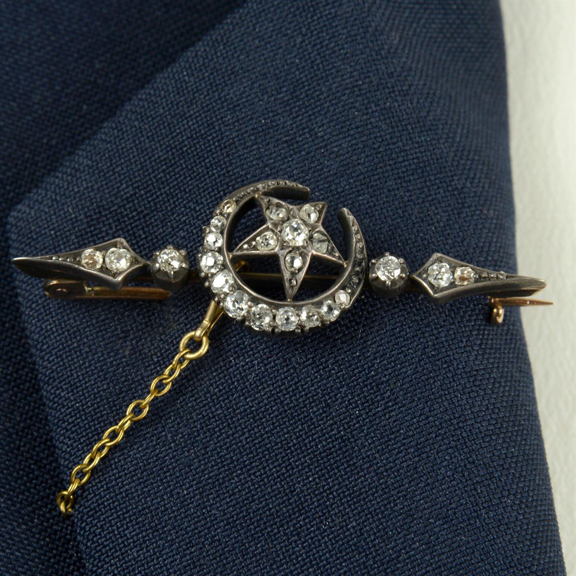 A late Victorian silver and gold old-cut diamond crescent moon and star bar brooch.