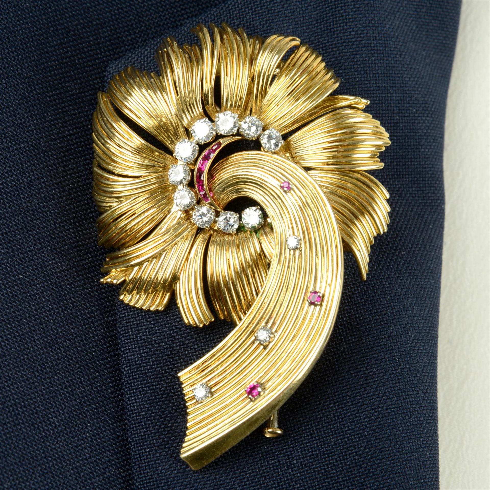 A mid 20th century platinum and 18ct gold brilliant-cut diamond and ruby stylised floral brooch.