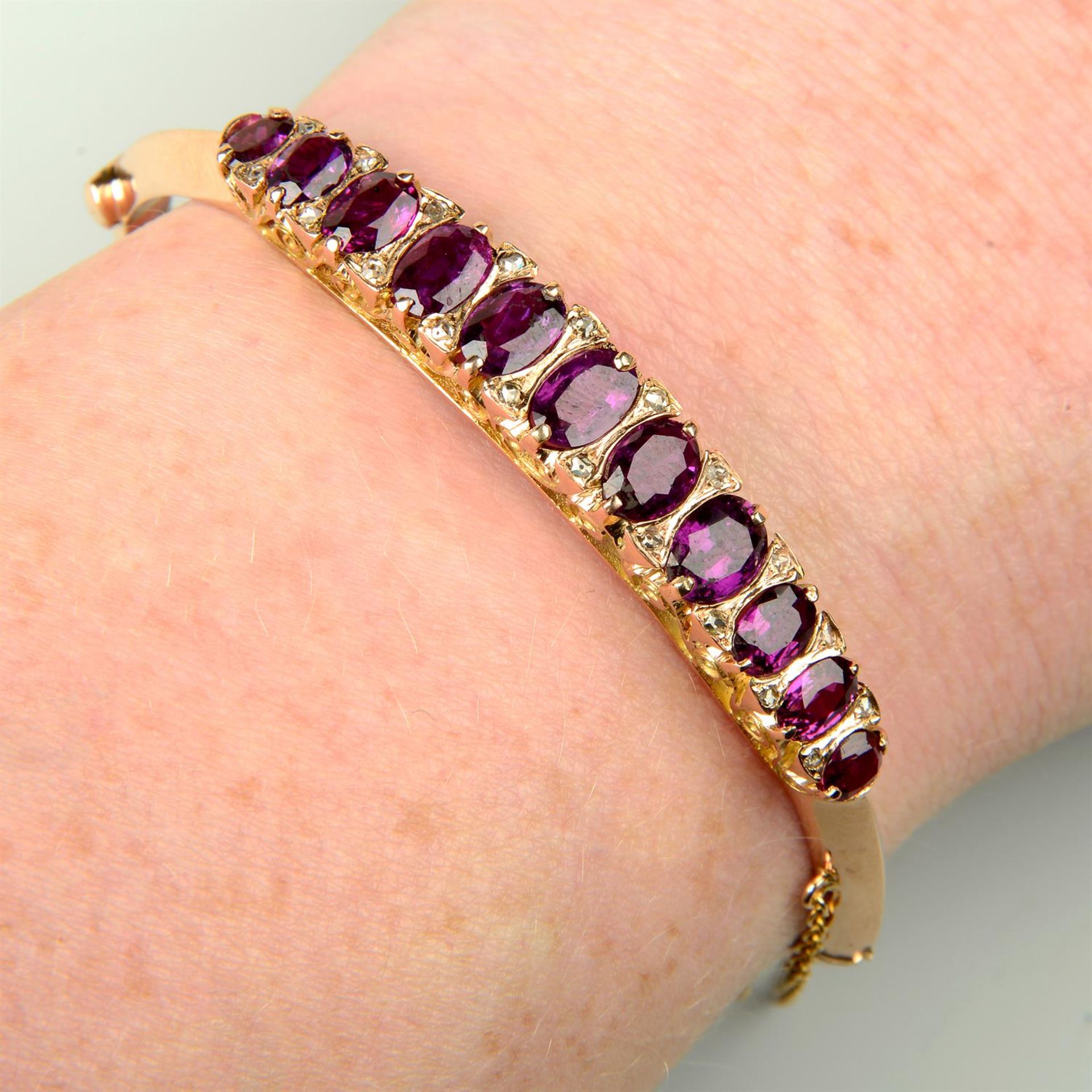 An early 20th century 15ct gold ruby and diamond point hinged bangle.