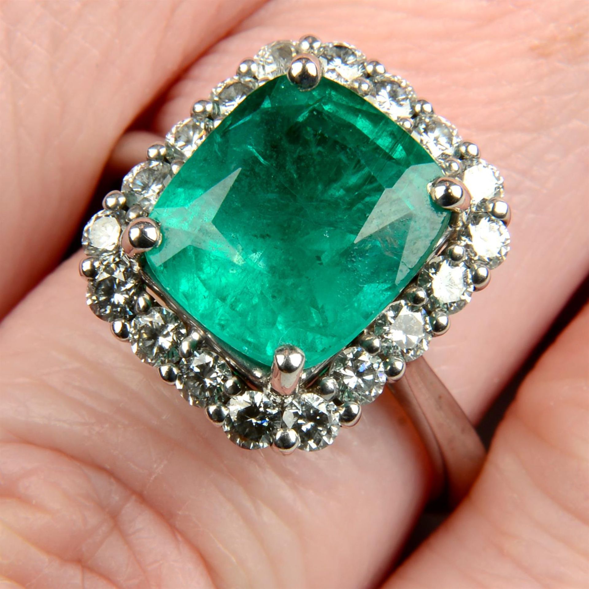 An 18ct gold emerald and brilliant-cut diamond cluster ring.