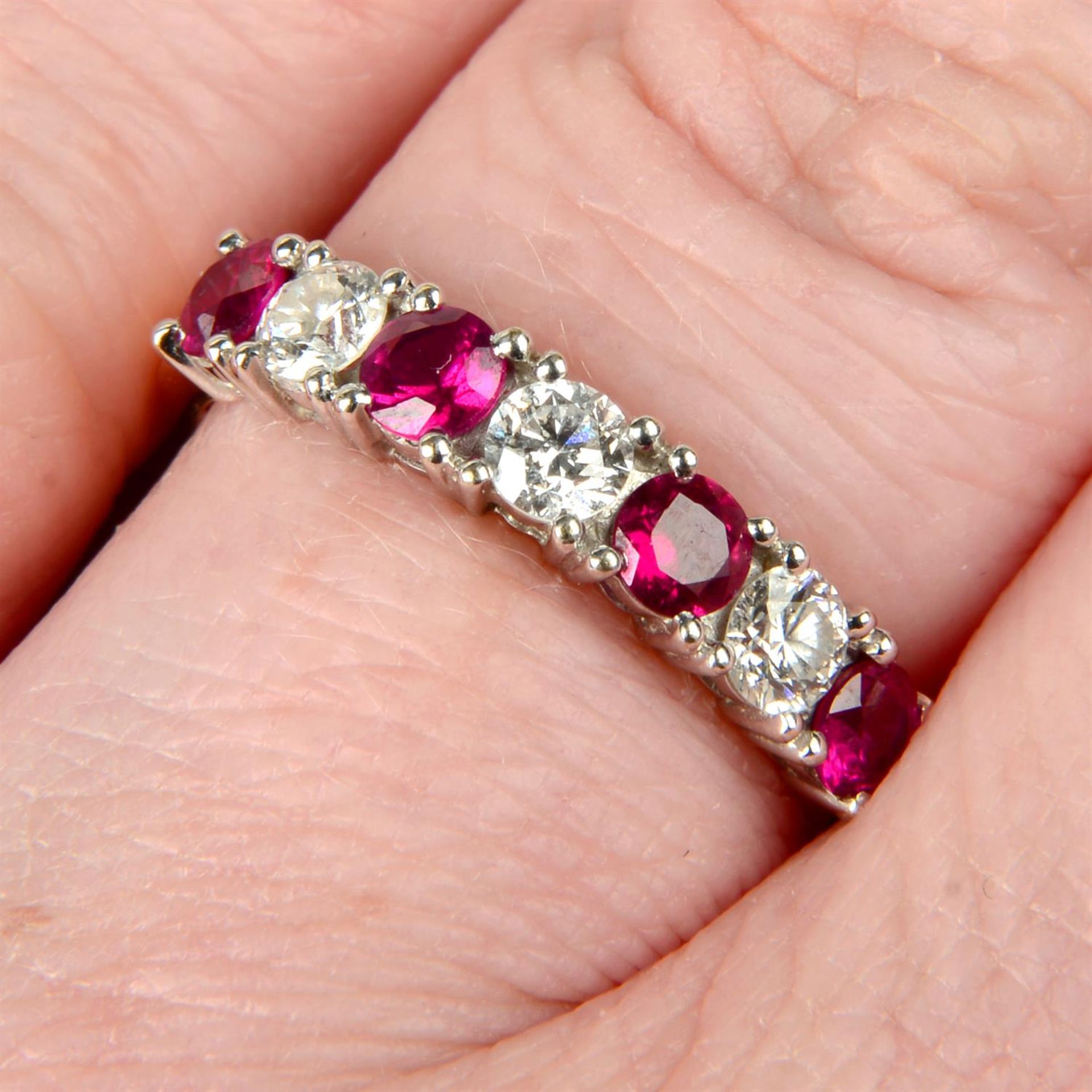 An 18ct gold alternating brilliant-cut diamond and ruby half eternity ring.