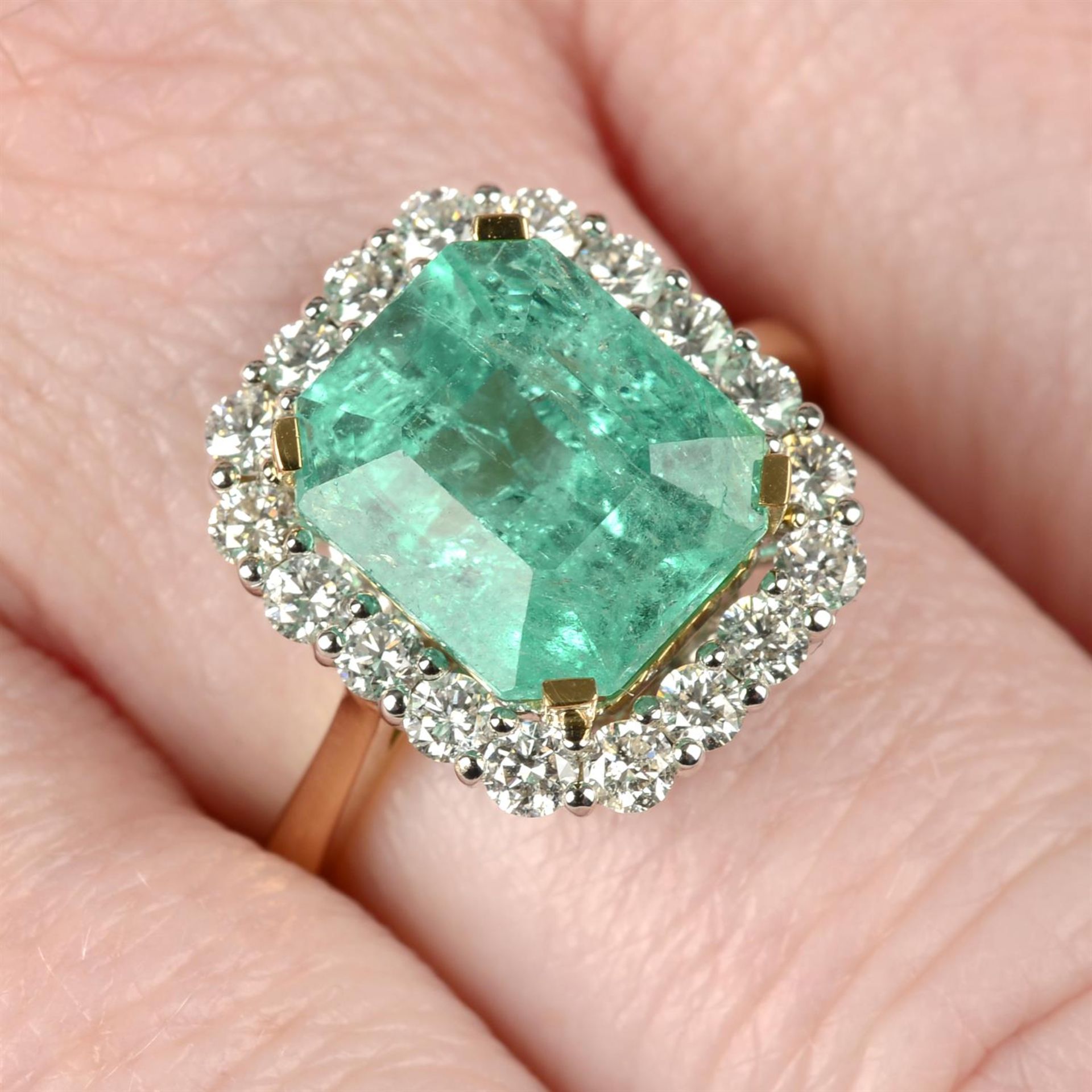 An 18ct gold Colombian emerald and brilliant-cut diamond cluster ring.