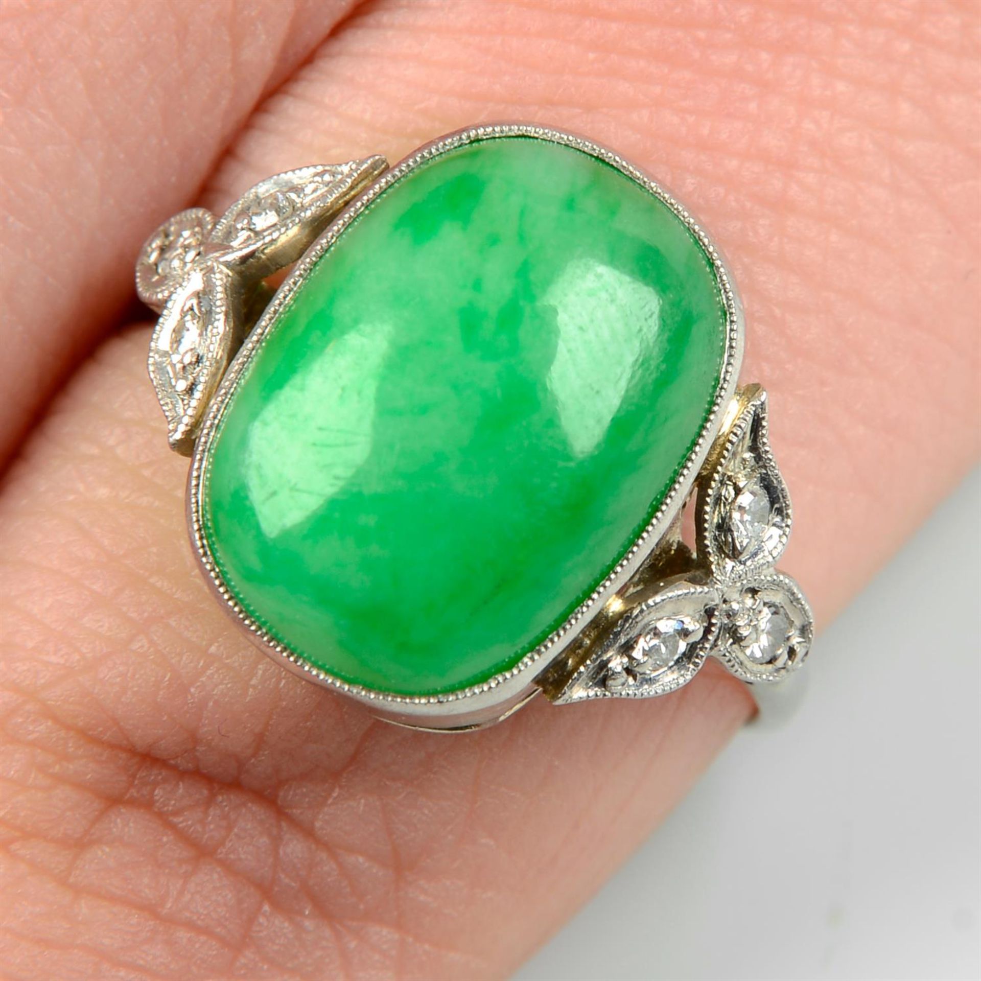 An early to mid 20th century platinum and 18ct gold jadeite jade ring, with single-cut diamond