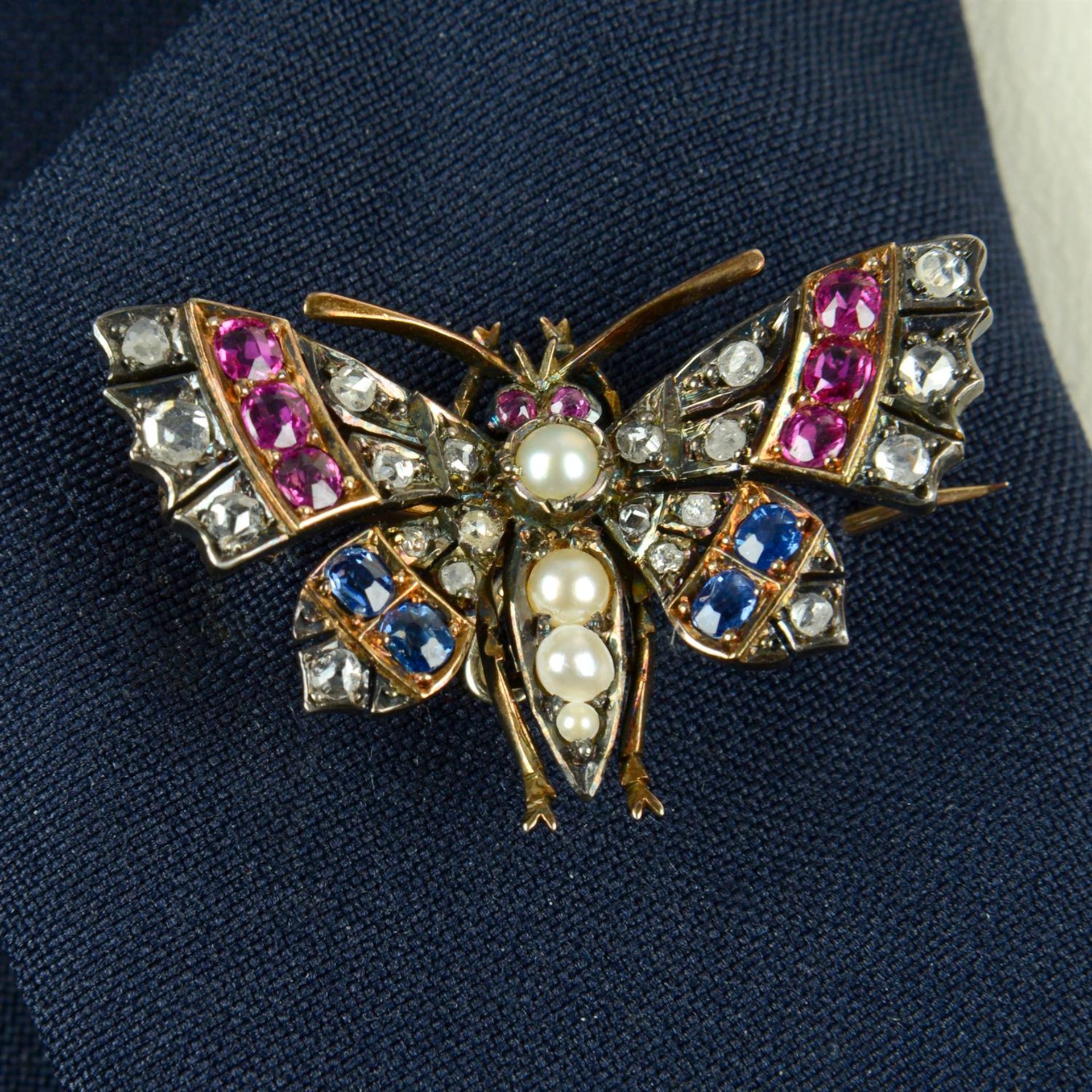 A late Victorian silver and gold split pearl butterfly brooch, with ruby, sapphire and diamond