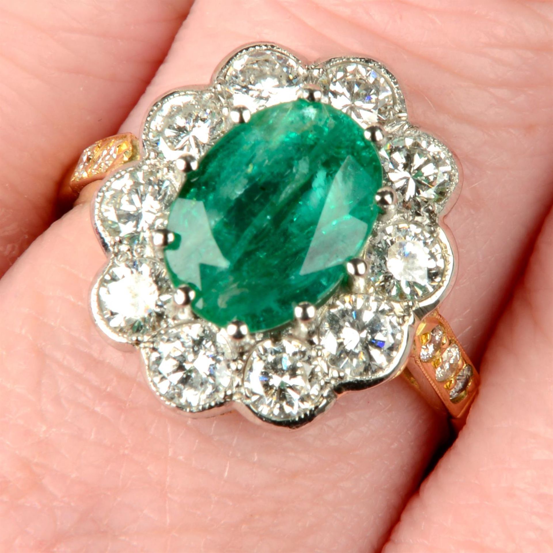 An emerald and brilliant-cut diamond cluster ring.