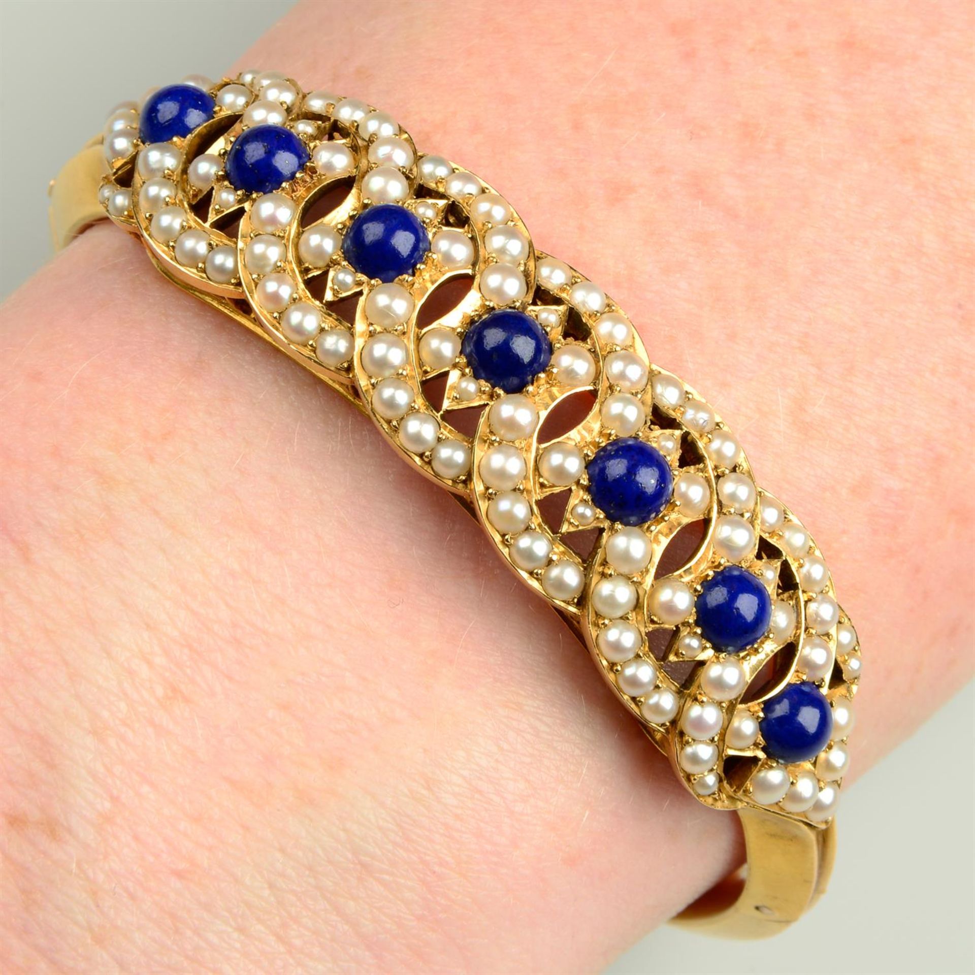 A Victorian gold lapis lazuli and split pearl hinged bangle.