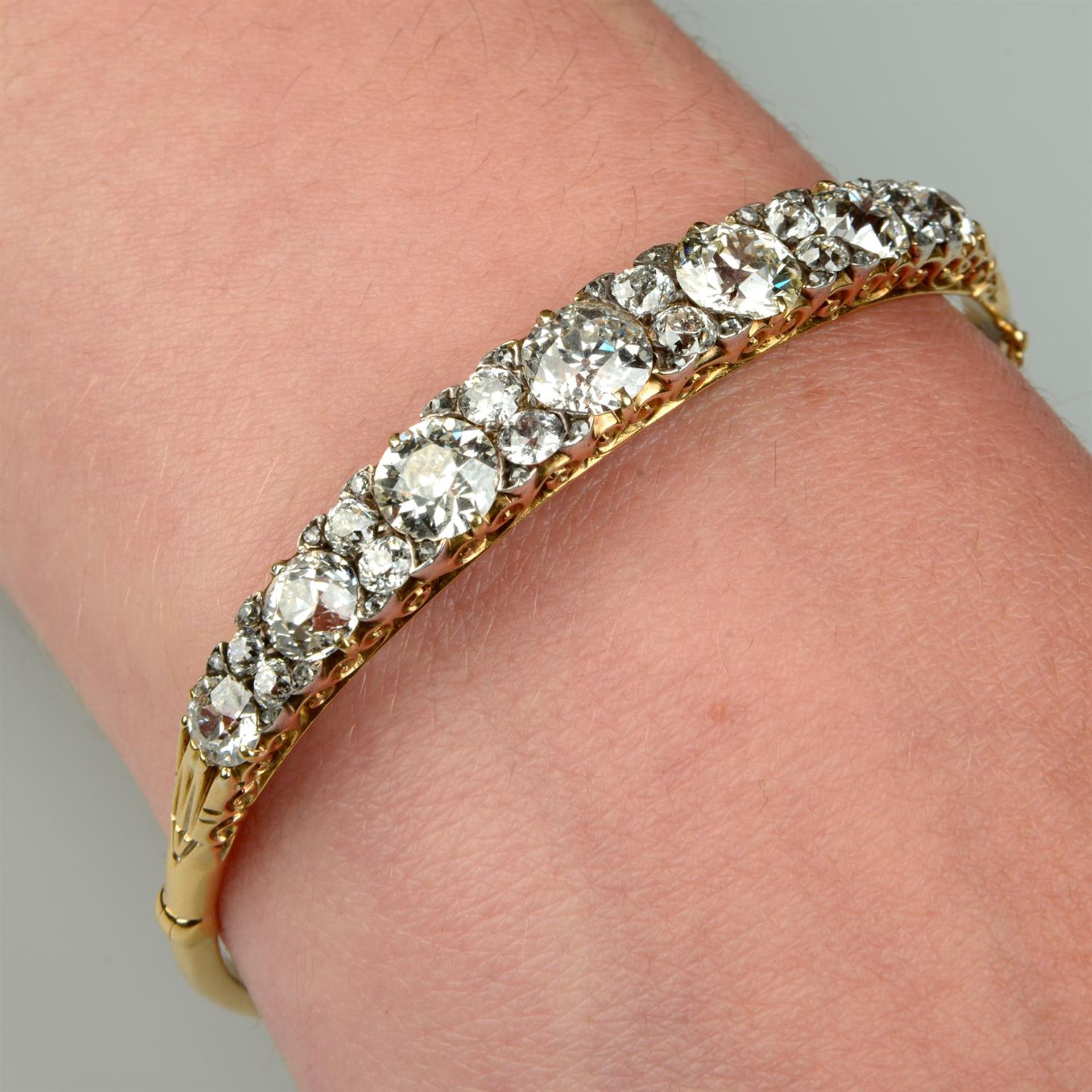 A Victorian 18ct gold slightly graduated old-cut diamond line hinged bangle.