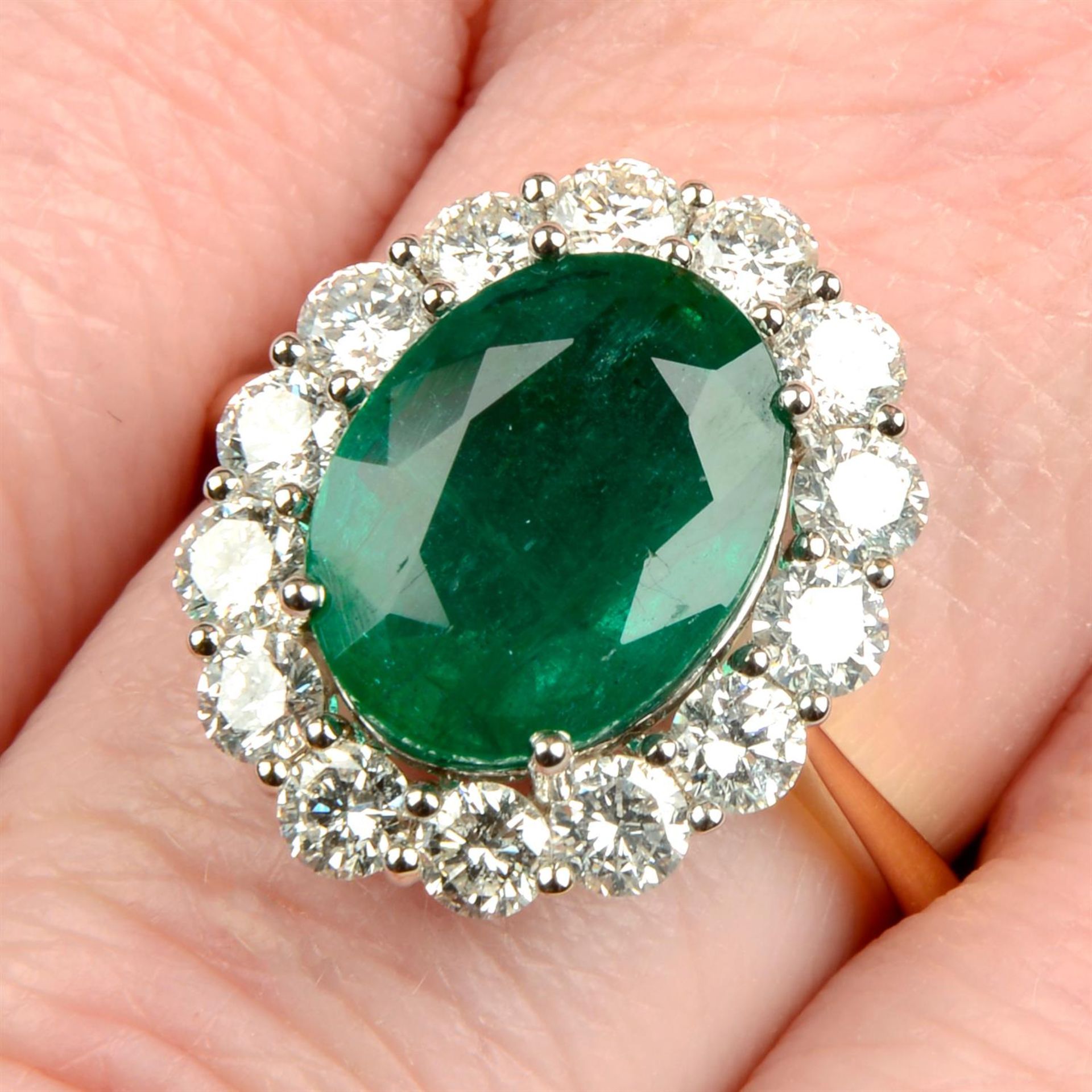 An 18ct gold emerald and brilliant-cut diamond cluster ring.