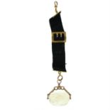 A late 19th century black fabric albertina, with 9ct gold fittings, suspending a citrine swivel fob.