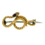 A late 19th century brooch, in the form of a coiled snake, with garnet crest.