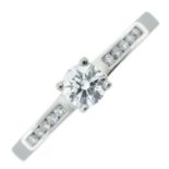 A platinum brilliant-cut diamond single-stone ring, with brilliant-cut diamond shoulders.