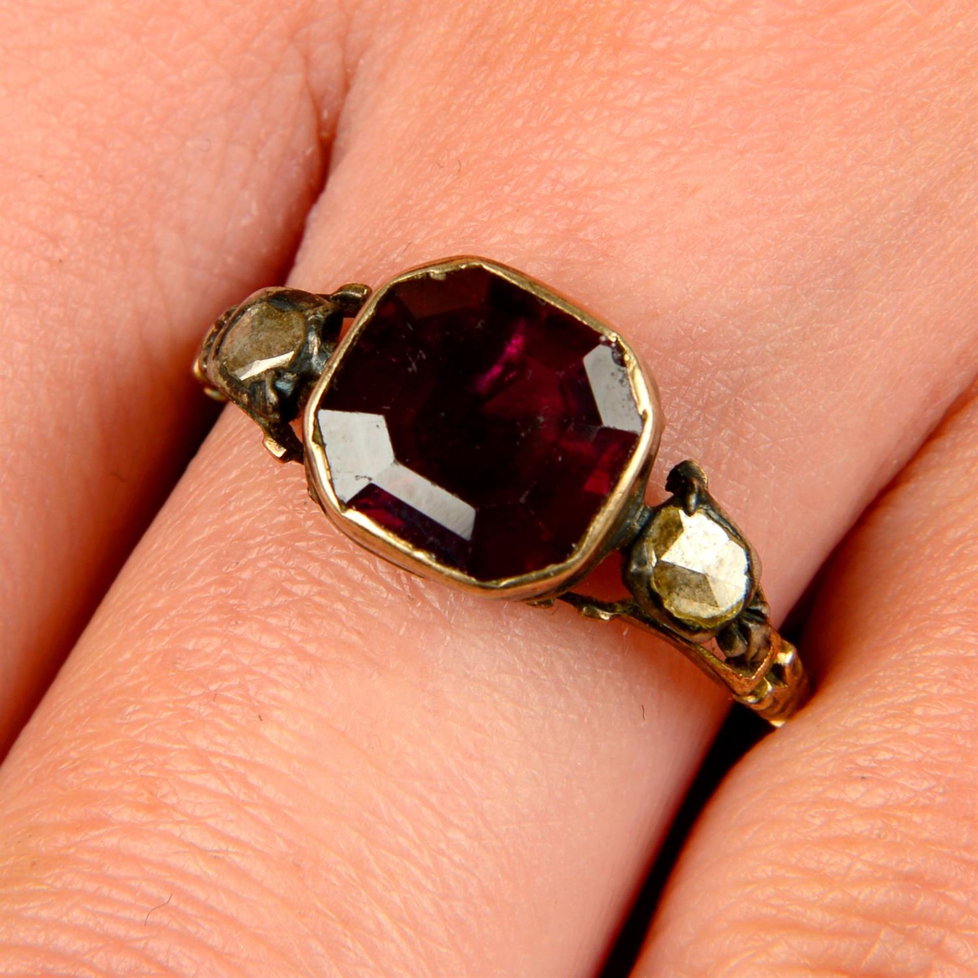 A Georgian silver and gold, foil-back garnet ring, with rose-cut diamond shoulders.
