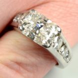 A platinum rectangular-shape diamond single-stone ring, with brilliant-cut diamond shoulders,