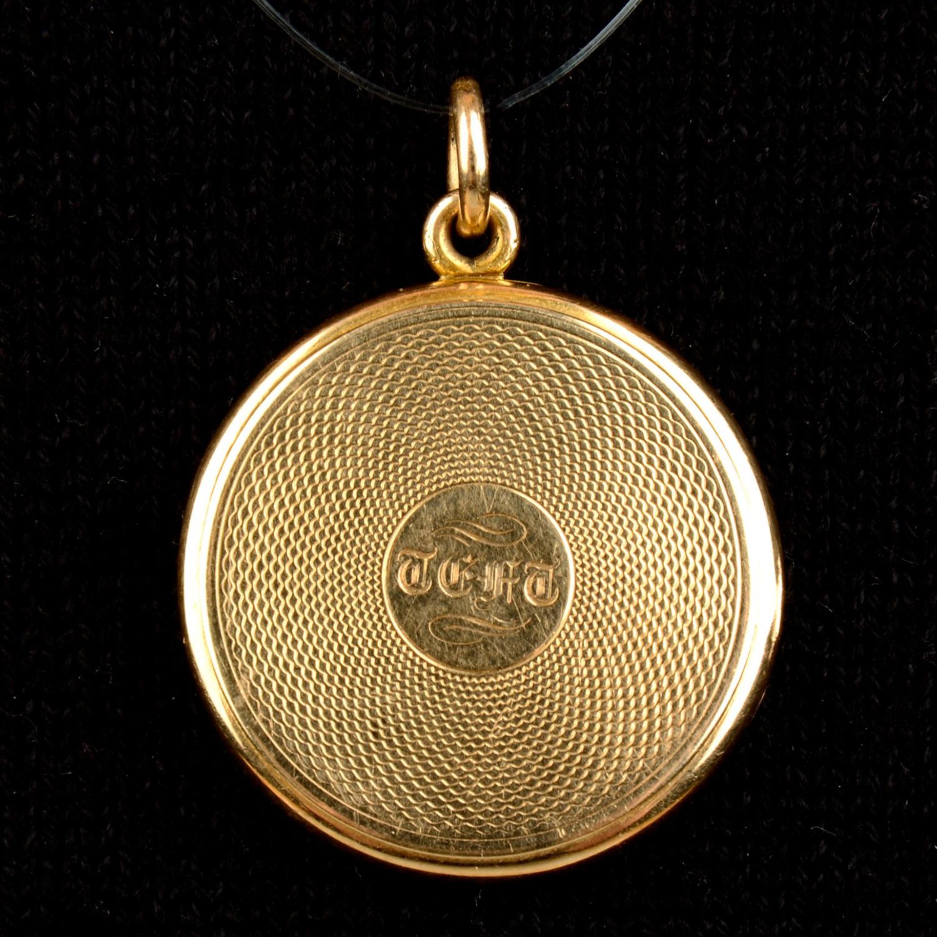 An early 20th century 15ct gold engine-turned circular locket, with glazed portrait miniature and