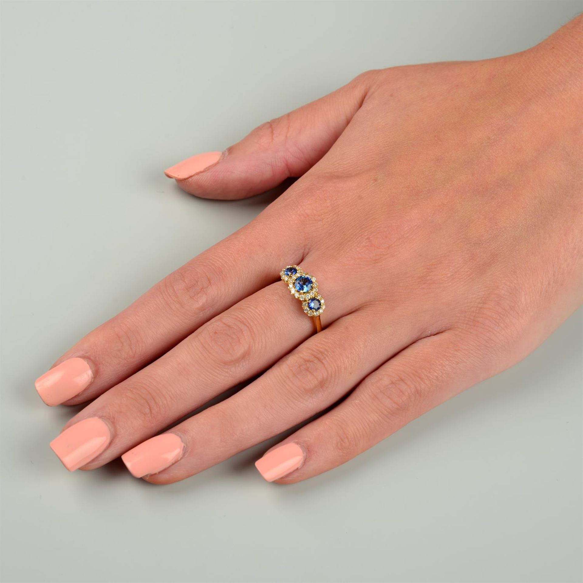 An 18ct gold graduated sapphire three-stone ring, with brilliant-cut diamond shared surround. - Bild 5 aus 5