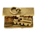 A 9ct gold station charm, with an engine to the reverse.
