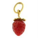 A carved coral and enamel strawberry pendant.