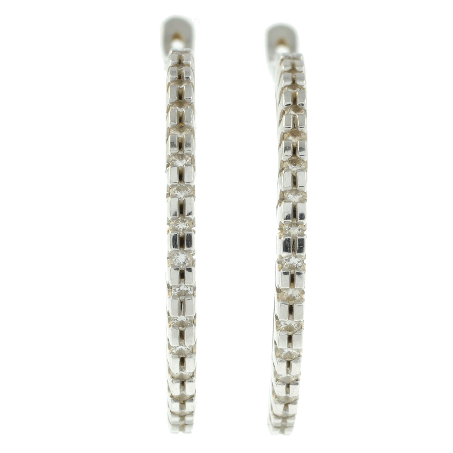 A pair of diamond hoop earrings.