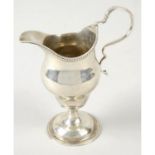 A George III silver pedestal cream jug.