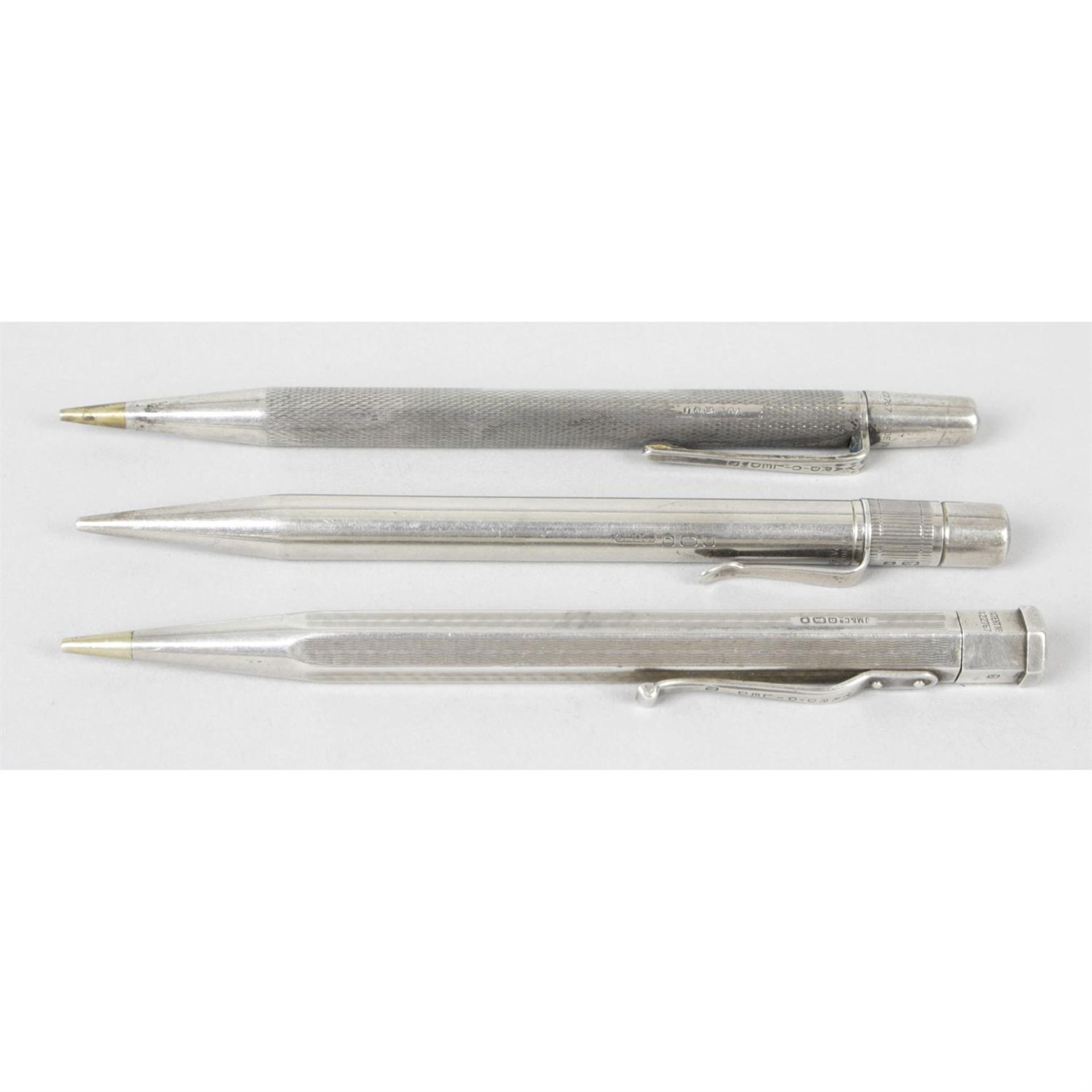 Three silver cased pencils.