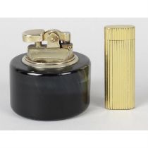 A Cartier cigarette lighter, together with a similar example.