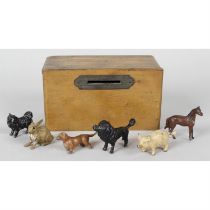 An early twentieth century stained wooden money box with a small selection of miniature animals.