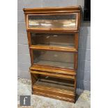 A Globe Wernicke oak four tier modular bookcase with glazed panel doors above a plinth base,