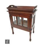 An Edwardian style floorstanding drinks cabinet fitted with a loose tray on a bevelled glass