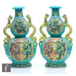 A pair of Chinese 'Dragon' vases, each of double gourd form rising from splayed footrim, relief cast