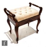 An Edwardian walnut piano stool of rectangular form, with twin rail sides above the lift-up seat and