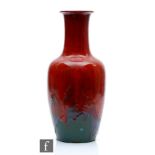 A Chinese flambe glazed bottle vase, the purple and mauve glazes swirling at the base and rising