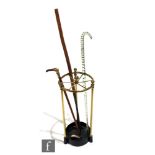 A Victorian circular brass stick stand with six divisions, three supports to a cast iron base,
