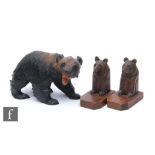 A pair of 20th Century wooden bookends decorated with carved stylised bears, with wooden base,