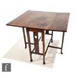 An Arts and Crafts oak gate leg tea table of rectangular form in the manner of Liberty & Co,
