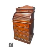 A Victorian style mahogany cylinder desk of small proportions with fitted drawer interior over a
