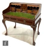 A late 20th Century reproduction mahogany Carlton House style desk, with inlaid oval paterae above a