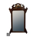 An early 20th Century Chippendale style mahogany and parcel gilt wall mirror, the bevelled edge