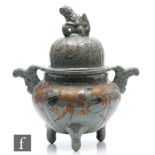 A Chinese Guan type celadon censer raised on tripod supports, applied with relief moulded handles